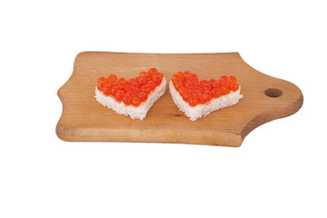 Two pieces of bread in the form of a heart and red caviar