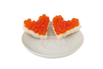 Two pieces of bread in the form of a heart and red caviar