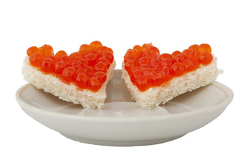 Two pieces of bread in the form of a heart and red caviar