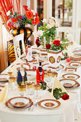 Luxuriant table appointments with red  china porcelain and rose