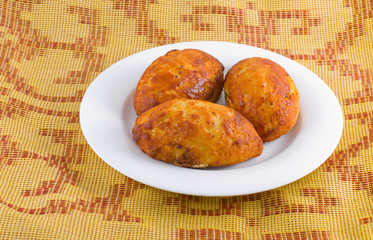 Three curd patties on a white plate.