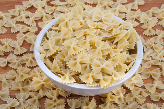 Raw pasta in white bowl