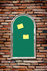 yellow paper with green board on old brick wall
