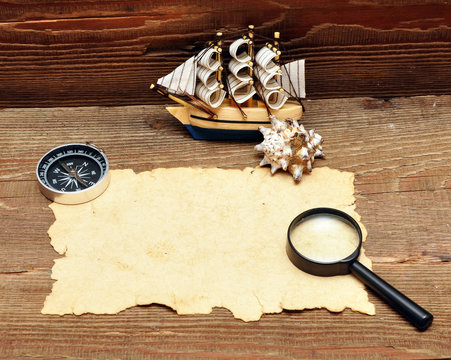 model classic boat, compass and rope on wood background