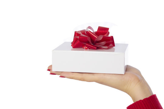 Gift with red bow placed on female hand