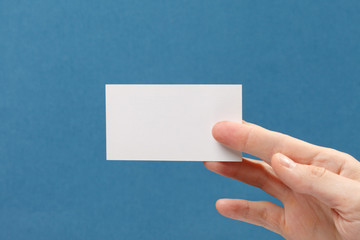 businessman's hand holding blank white paper business card