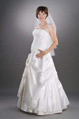 Fototapeta na wymiar pretty pregnant bride wearing wedding gown