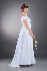 Fototapeta na wymiar the pregnant bride in wedding dress with apple flower