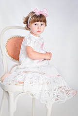 sweet little girl waiting for present sitting on the chair