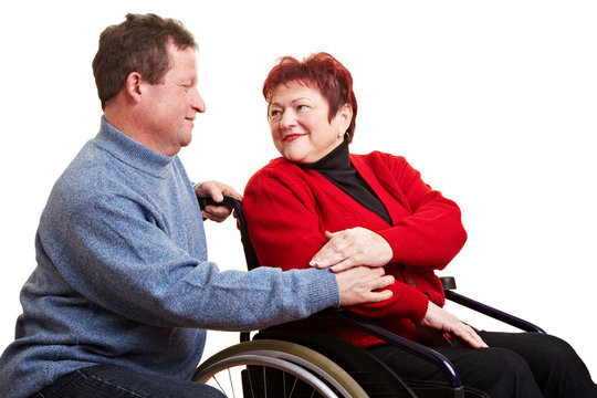 Ehemann unterstützt Frau im Rollstuhl