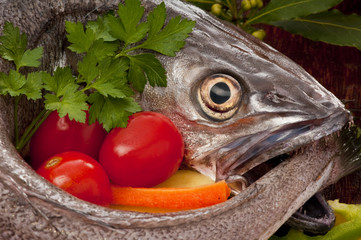 Young hake fish being prepared for cooking with a variety of veg