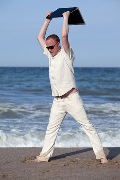 Angry Man Throwing His Laptop At The Beach