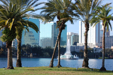 Orlando, Florida. Lake Eola and palm trees in foreground. - obrazy, fototapety, plakaty