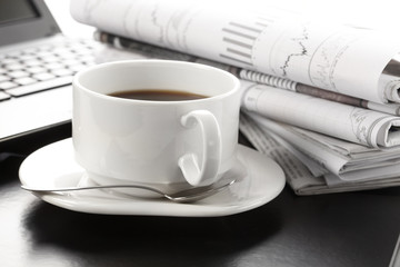 Cup of fragrant coffee on a morning paper business news