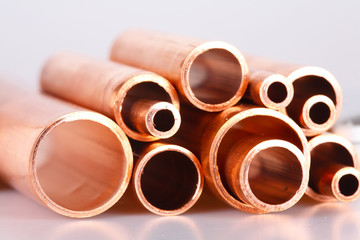 Set of copper pipes of different diameter lying in one heap