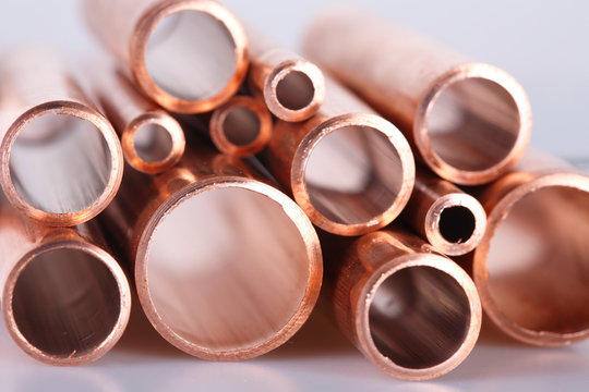 Set of copper pipes of different diameter lying in one heap