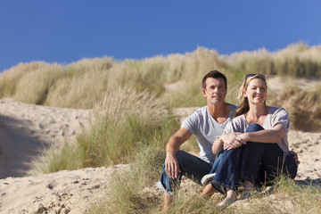 Romantic Man and Woman Couple Sitting Together On A Beach