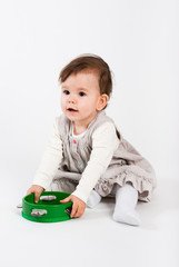 The little girl plays with wooden toys a white background