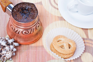Turkish coffee in copper coffee pot and cookies