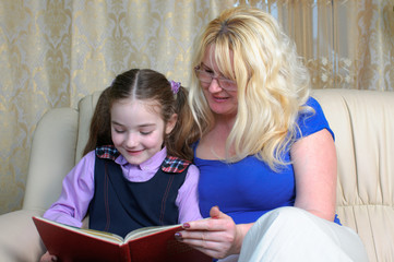 Little school girl and mother doing homeworks