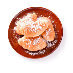 Croissants on a brown plate isolated on a white background