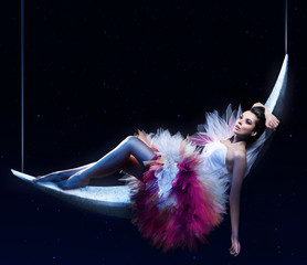 Beauty brunette lying on the crescent moon - obrazy, fototapety, plakaty