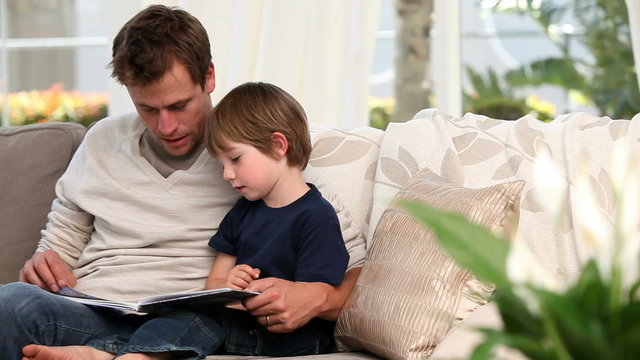 Man reading a book for his son