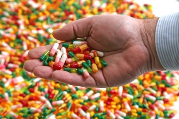 Hand full of medication pill capsules