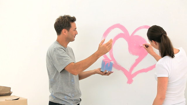 Nice couple paiting a wall together