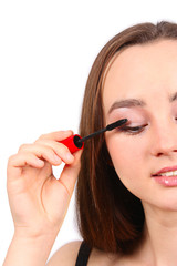 Fototapeta premium Young beautiful girl applying mascara