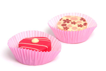 two delicious pink petit four over white background