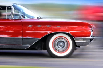 Cercles muraux Vielles voitures Voiture rouge classique en mouvement rapide sur route