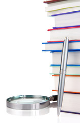 books and magnifying glass isolated on white