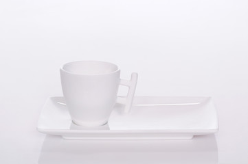 biała filiżanka na białym podstawku