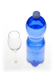 Blue bottle of mineral water and a glass, isolated on white.