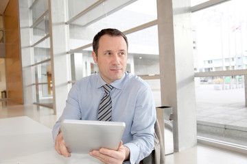 Businessman sitting in the office with electronic tablet