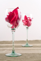 Conceptual Love Image with Rose Petals and Wine Glasses