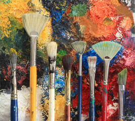 Artist brushes on an oil painting background.