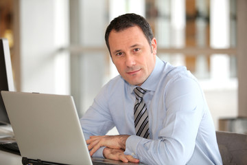 Fototapeta premium Portrait of businessman in front of laptop computer