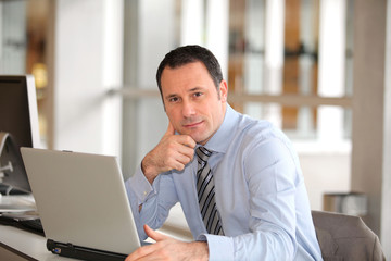 Fototapeta premium Portrait of businessman in front of laptop computer