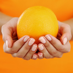 orange in woman hands