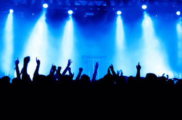 Fototapeta premium concert crowd in front of bright blue stage lights