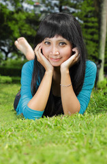 Naklejka na ściany i meble young asian beautiful girl relaxing on grass outdoor
