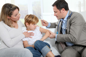 Doctor doing vaccine injection to little boy