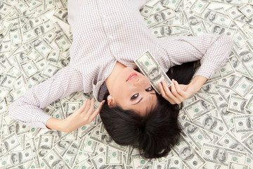 Young business woman resting upon money