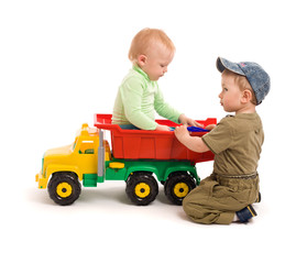 Two little boys play with toy truck