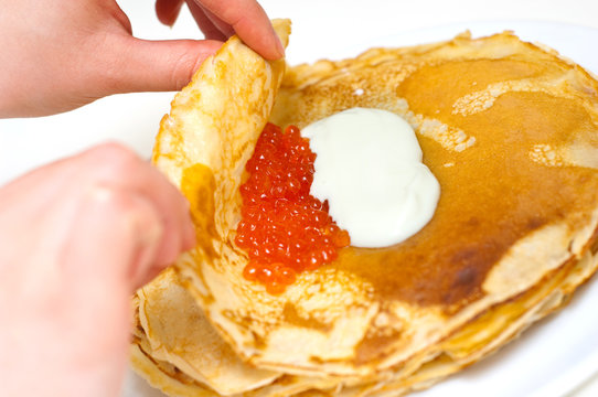 wrapping pancakes with caviar and sour cream