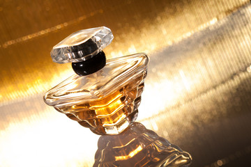 Fototapeta na wymiar Perfumy z refleksji na złotym tle