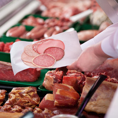 verkäuferin mit salami an der bedientheke