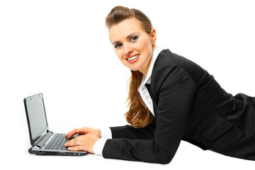 Laying on floor smiling modern business woman using  laptop